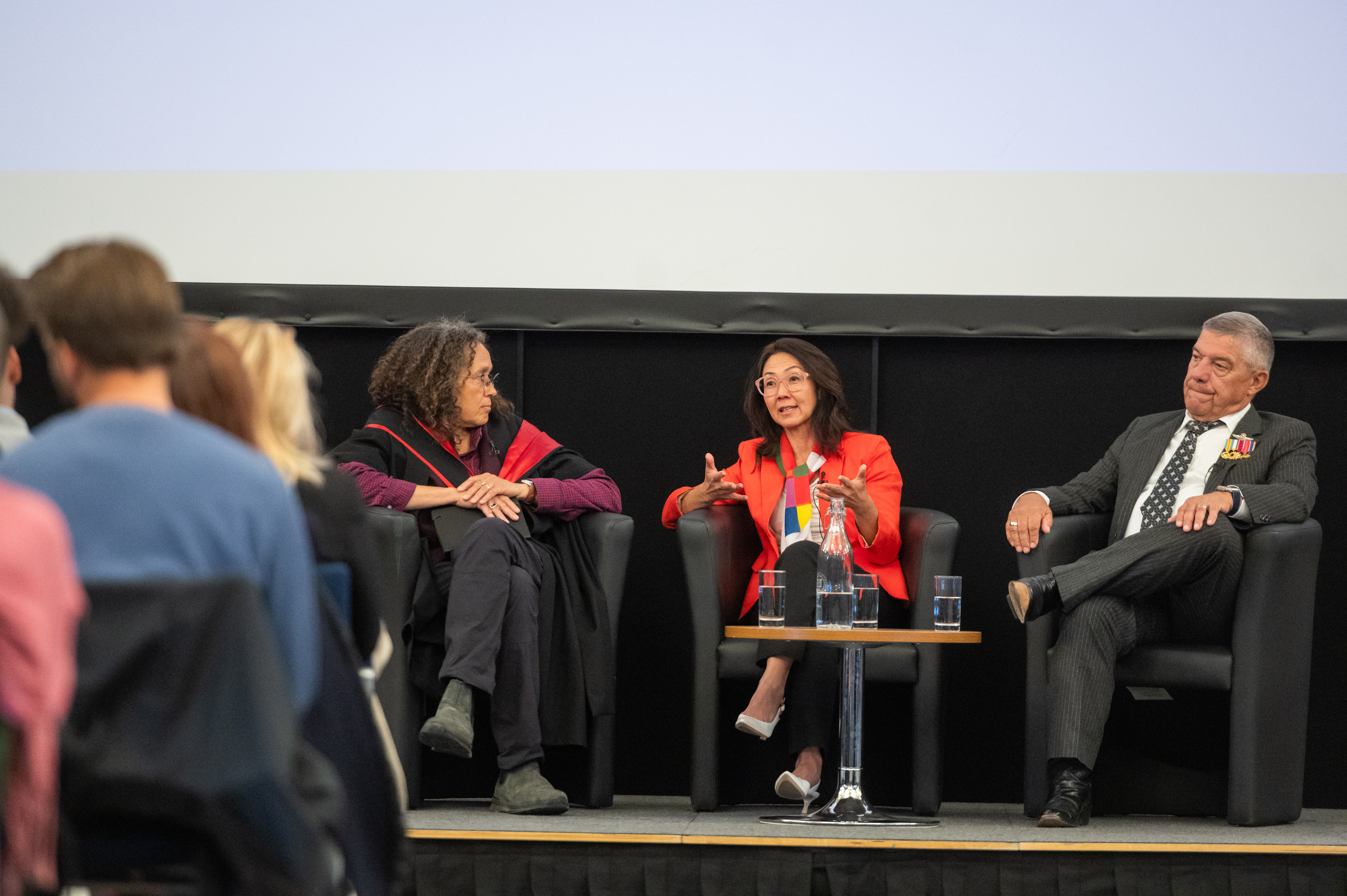 Image of a panel of  three people sat in front of an audience