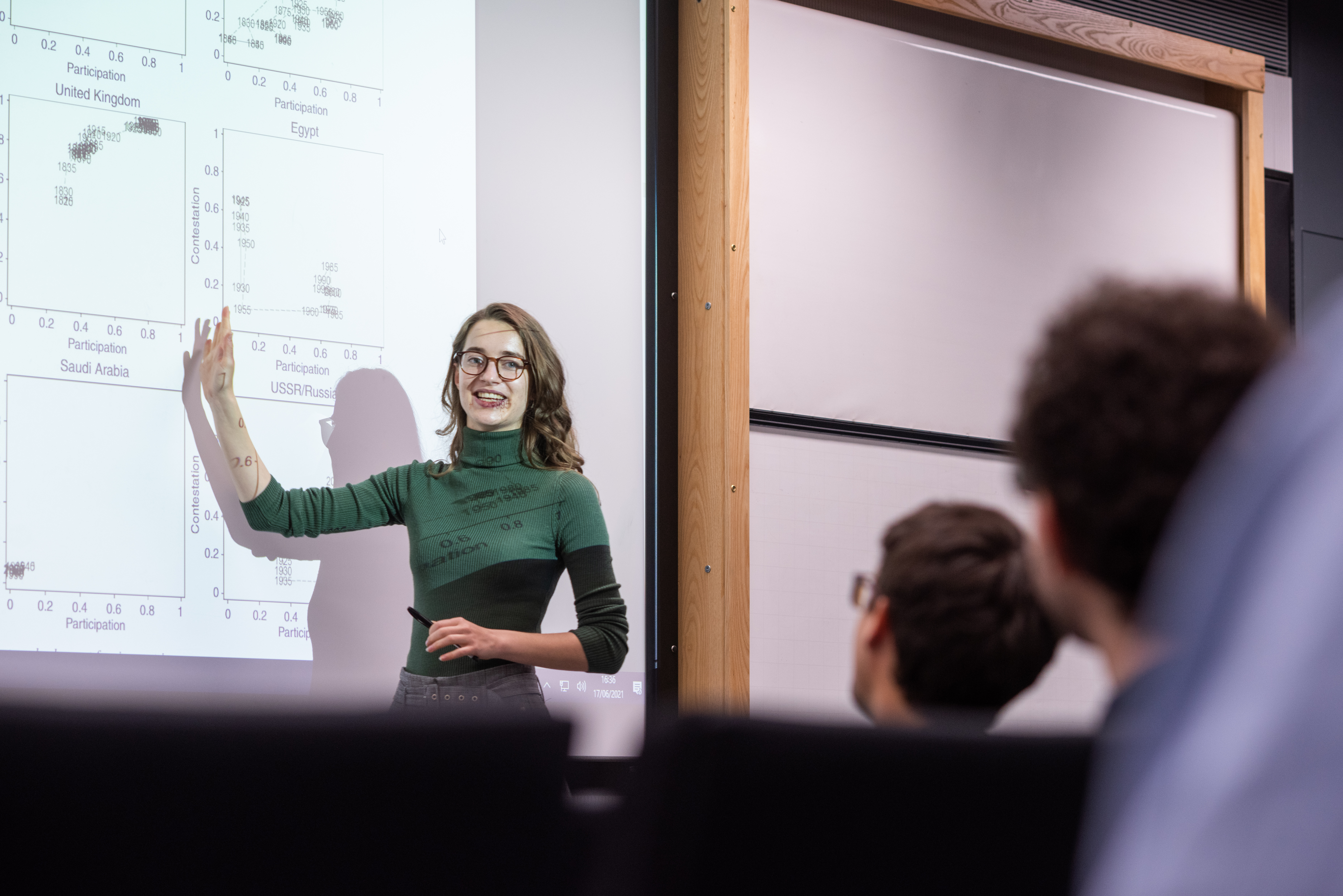 Image of a woman in front of a screen giving a lecture