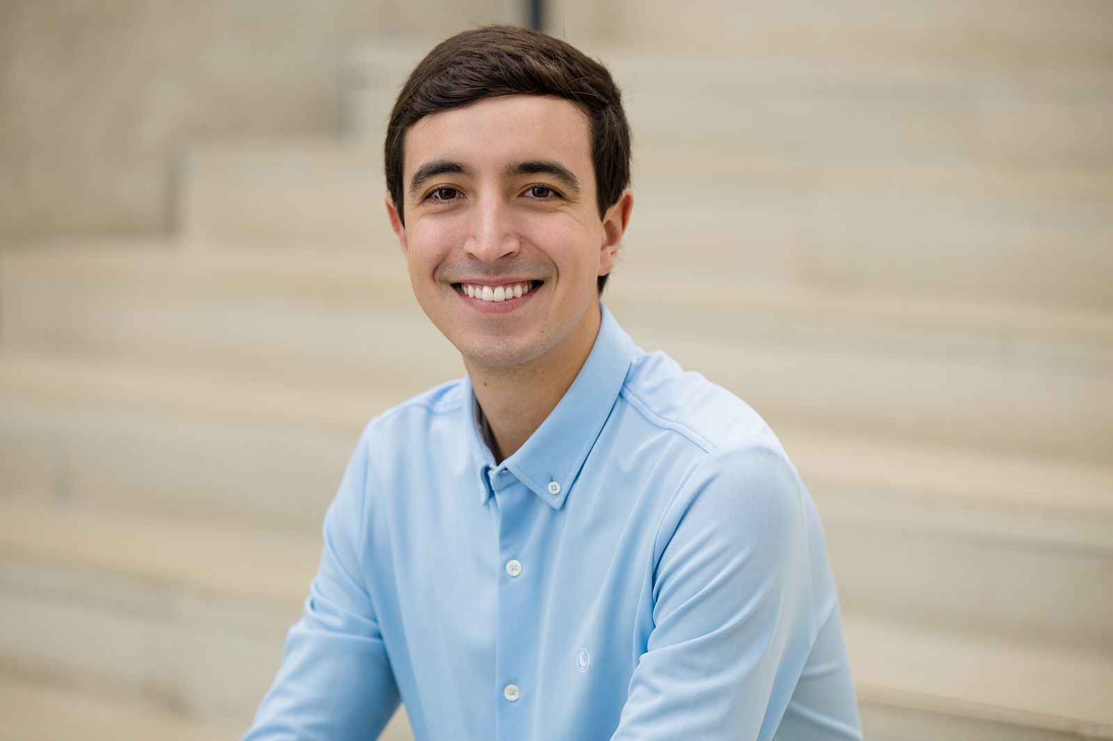 profile image of a man wearing a light blue shirt smiling at the camera
