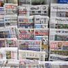 Rack with British and international newspapers outside newsagent's shop