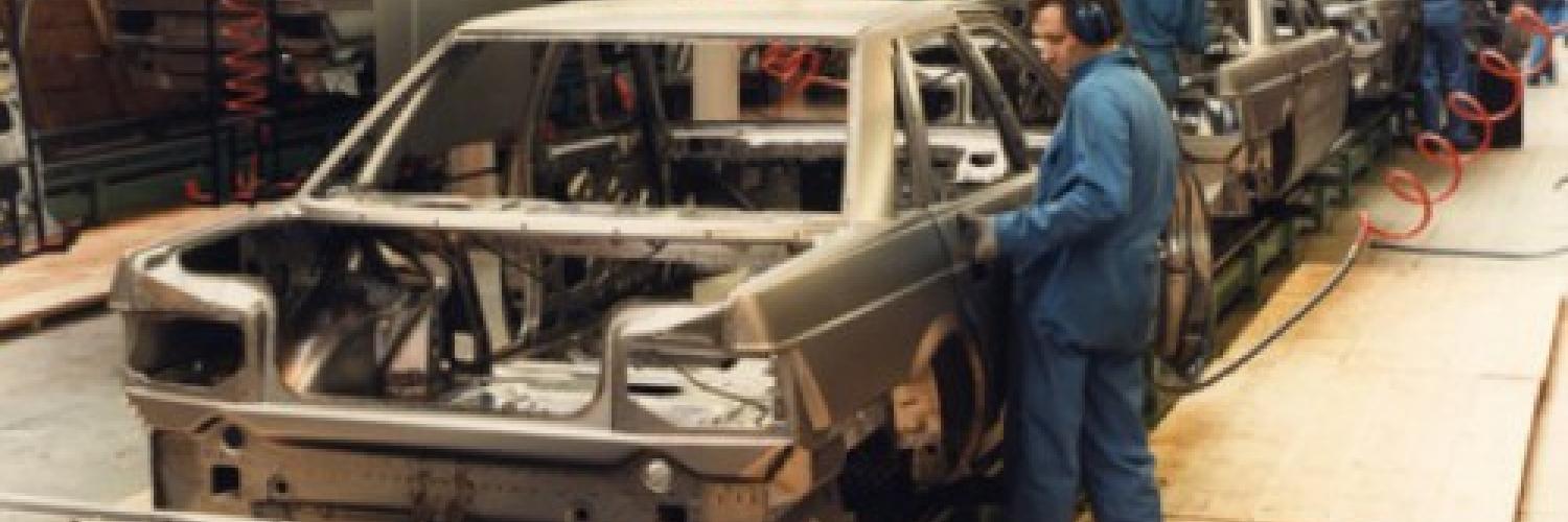 A worker working on a car at a car plant