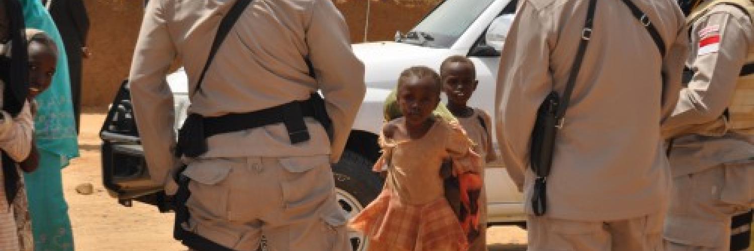 UN personnel in front of two children