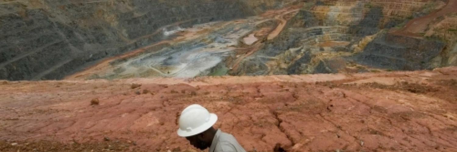 Image of a man in a helmet above a gold mine.