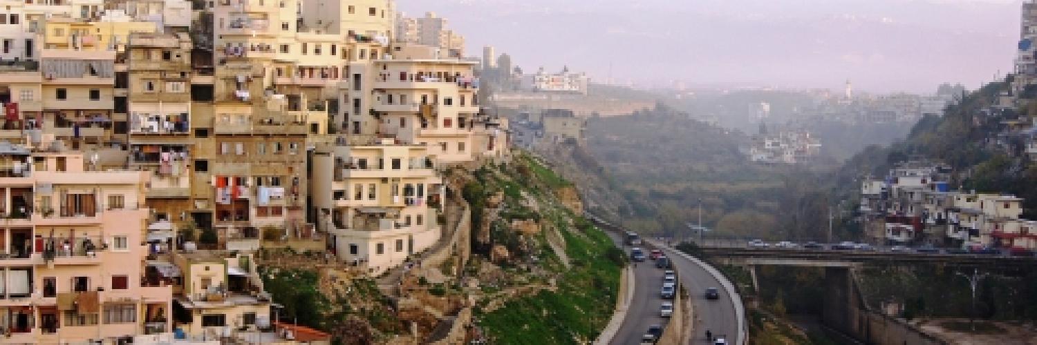 Image of buildings built into a hillside with a road running around the side below