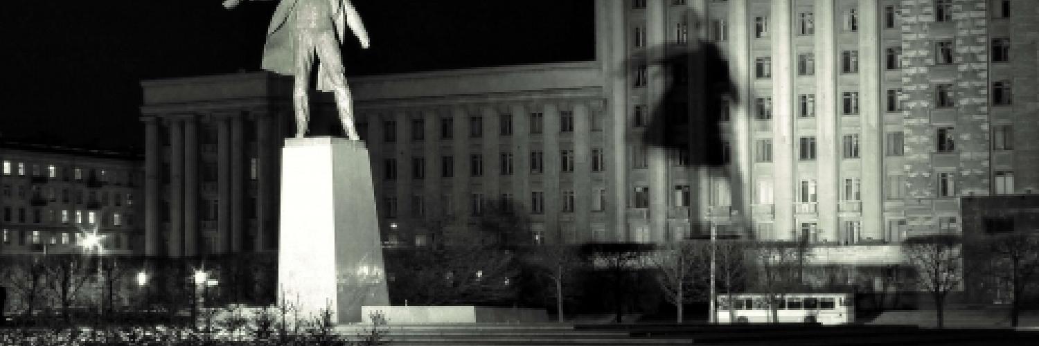 Image of a statue in the dark with a building in the background