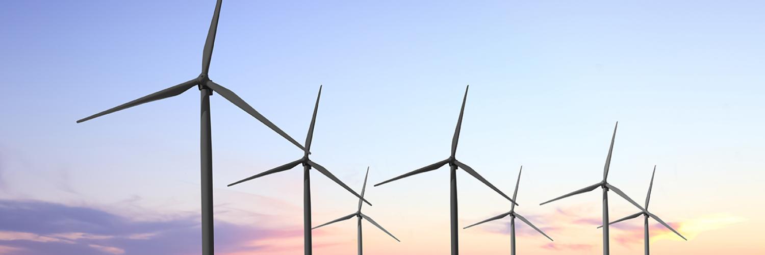 a row of wind turbines in a field.