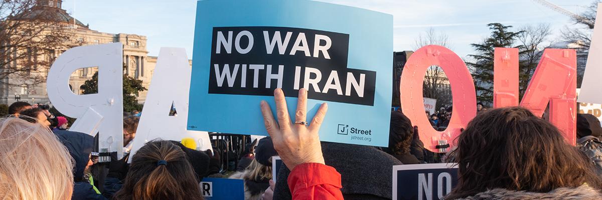 Protest with sign reading 'No War with Iran'