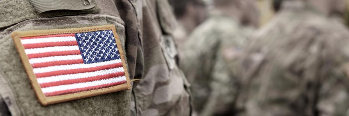 Close up image of a US soldier's arm with a US flag badge on his shoulder