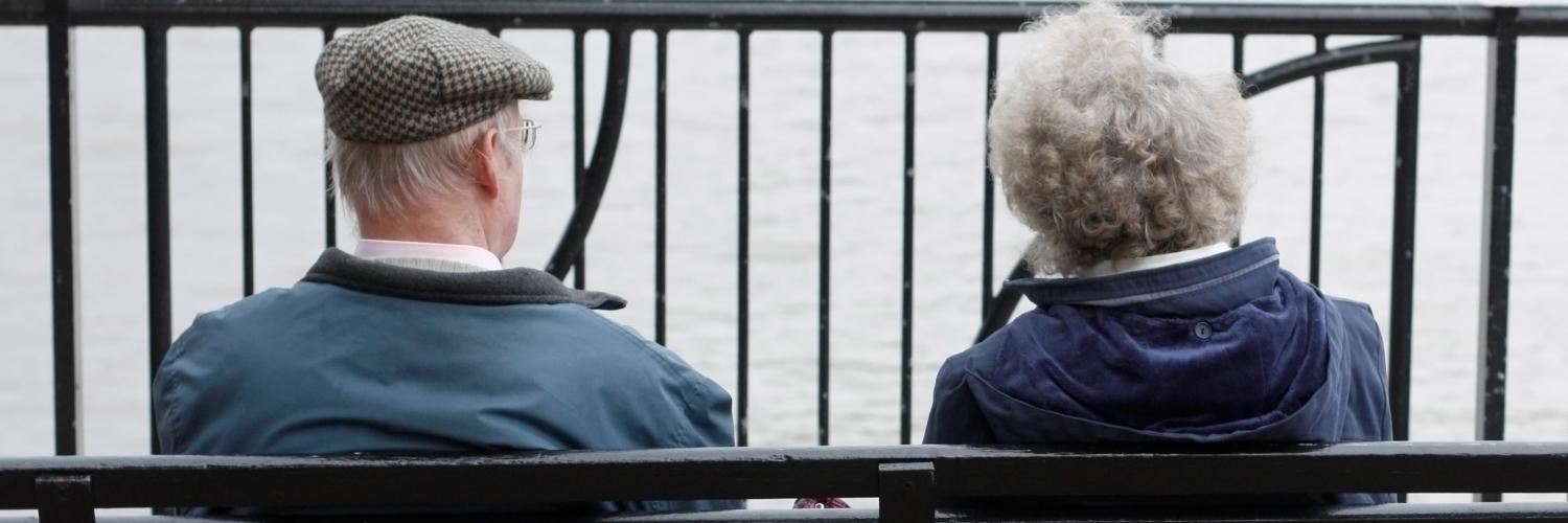 An elderly couple sitting on a bench