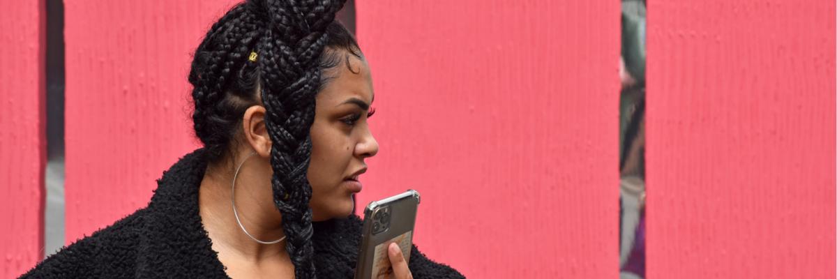 Woman with natural hair speaking on her phone in Manchester city centre