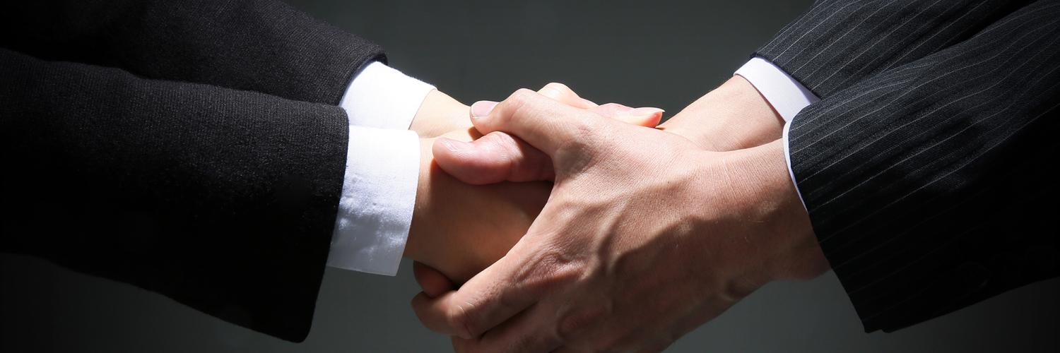 Two people in suits shaking hands