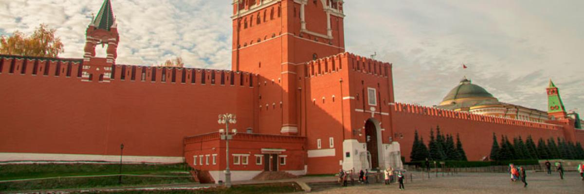 The red wall of a large building with a clock tower