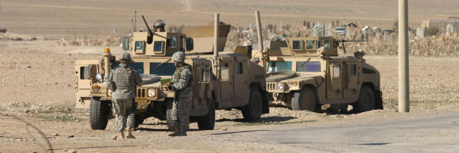 Army tanks on road in desert landscape