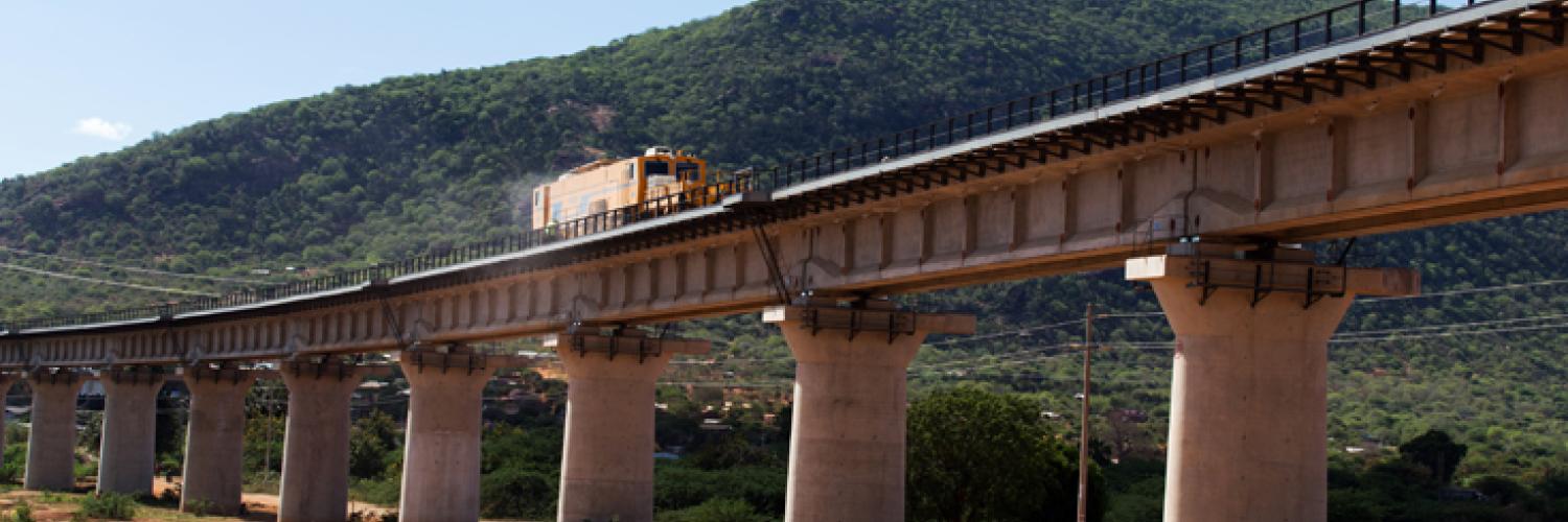  A picture containing outdoor, sky, train, bridge.