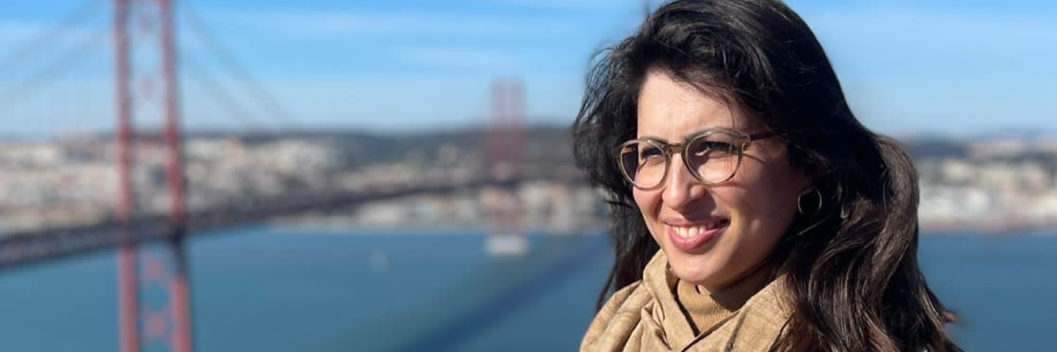 a woman smiling and looking past the camera, with San Francisco's Golden Gate Bridge in the background