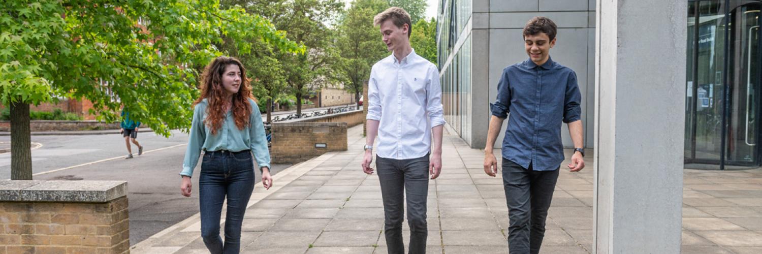 Three people walking together in a row, talking