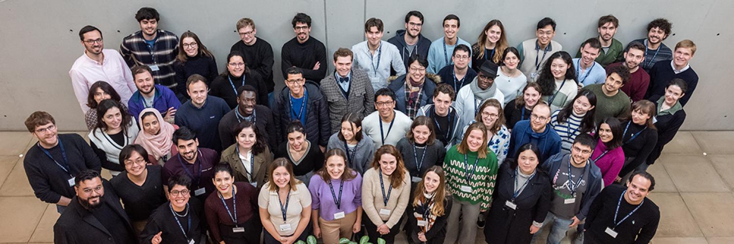 A large group of students photographed from above and looking upwards