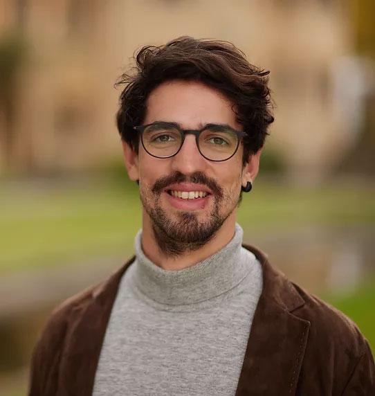 Image of a man wearing glasses smiling at the camera