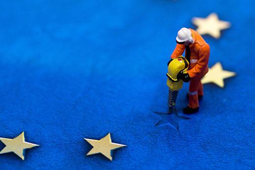 Graphic of a man in orange overalls and hardhat working a road drill on a star in the EU flag which is missing