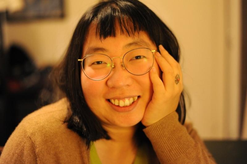 Image of a woman wearing glasses smiling at the camera