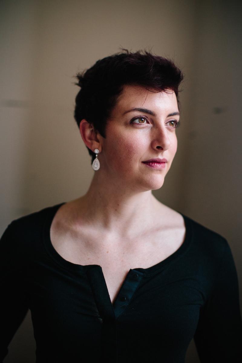 a side profile of a woman in a black top