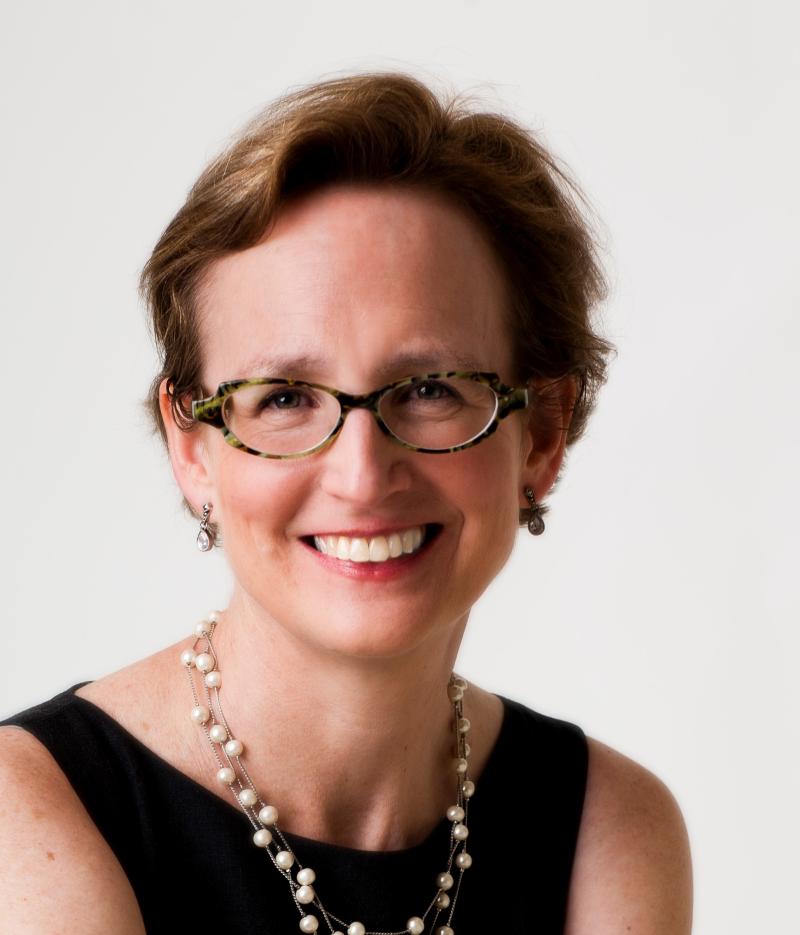 Image of a woman wearing glasses smiling at the camera