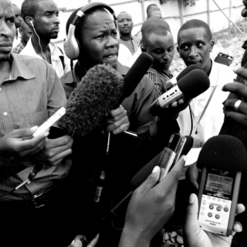 Photo of a group of journalists with microphones held in front of them