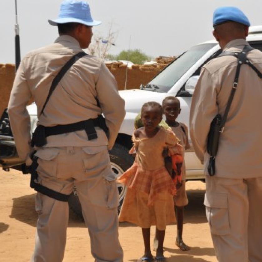 UN personnel in front of two children