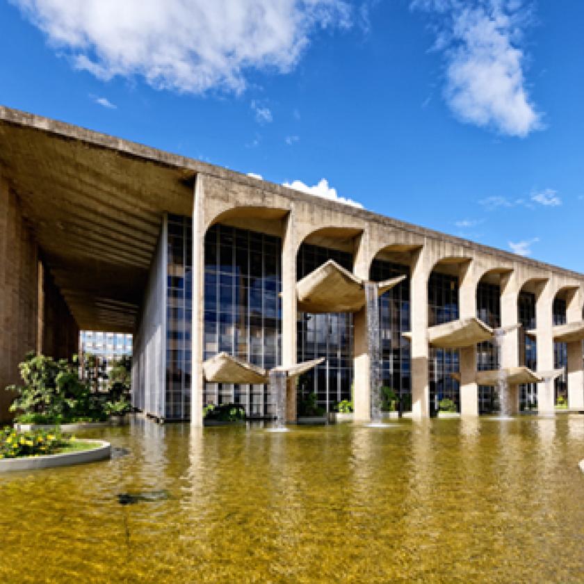 An image of a building with a large pond in front of it