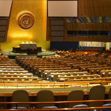 wide-angle photograph of United Nations Assembly Chamber, with hundreds of seats fanning out from stage 