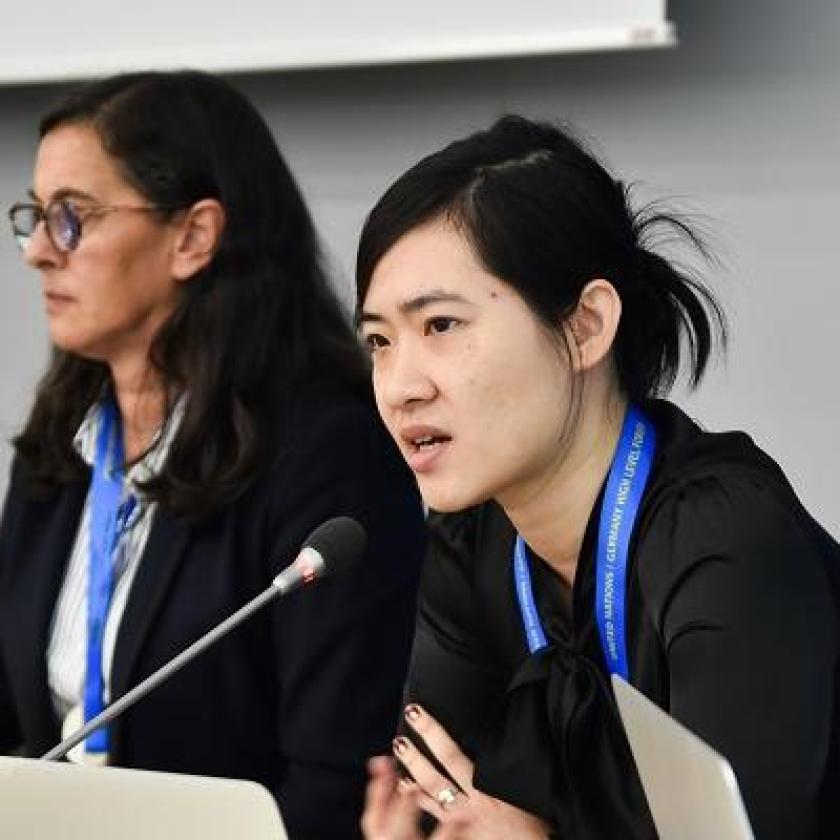 Two women sat next to one another in front of a microphone