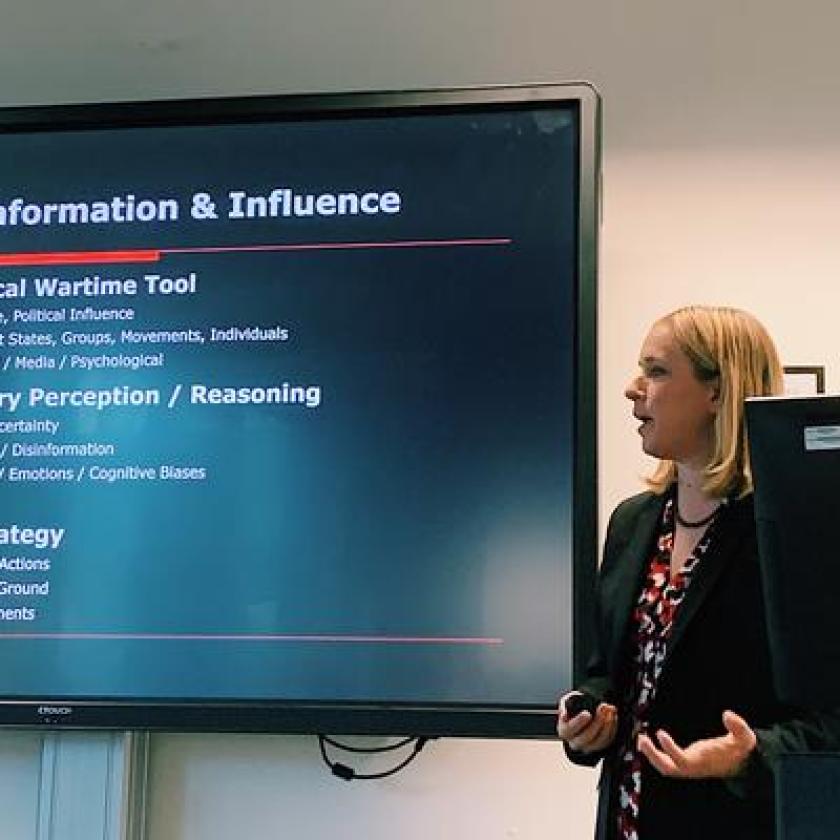 A woman presenting in front of a screen