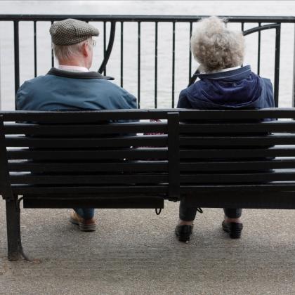 An elderly couple sitting on a bench
