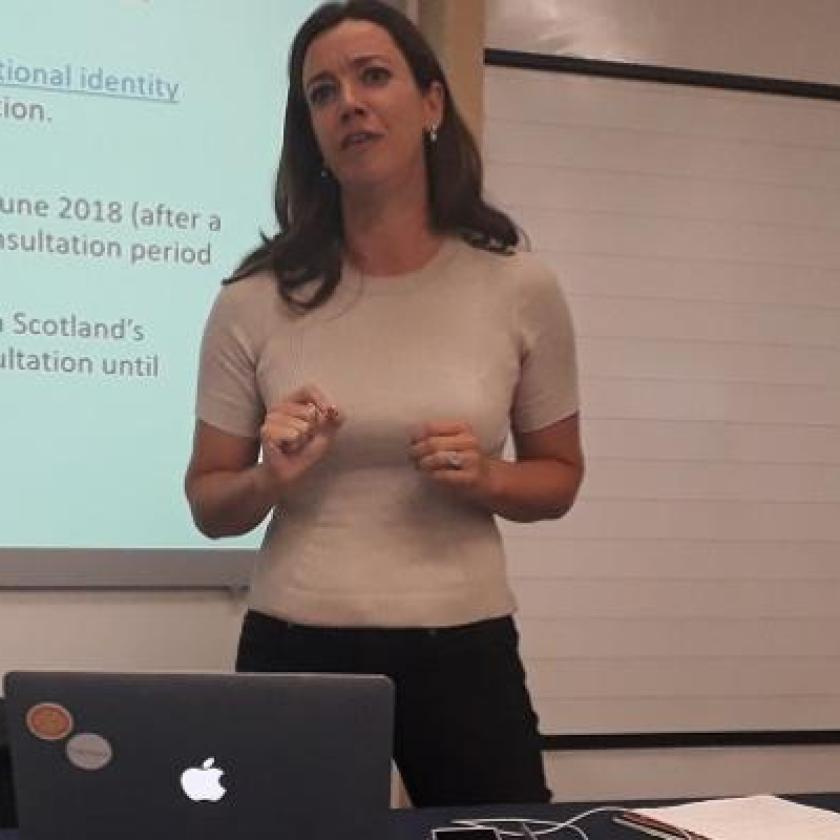 A woman stood in front of a screen