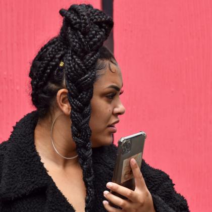 Woman with natural hair speaking on her phone in Manchester city centre
