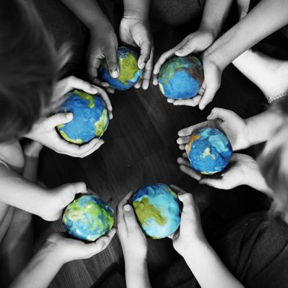 Group of diverse kids hands holding cupping globe balls together