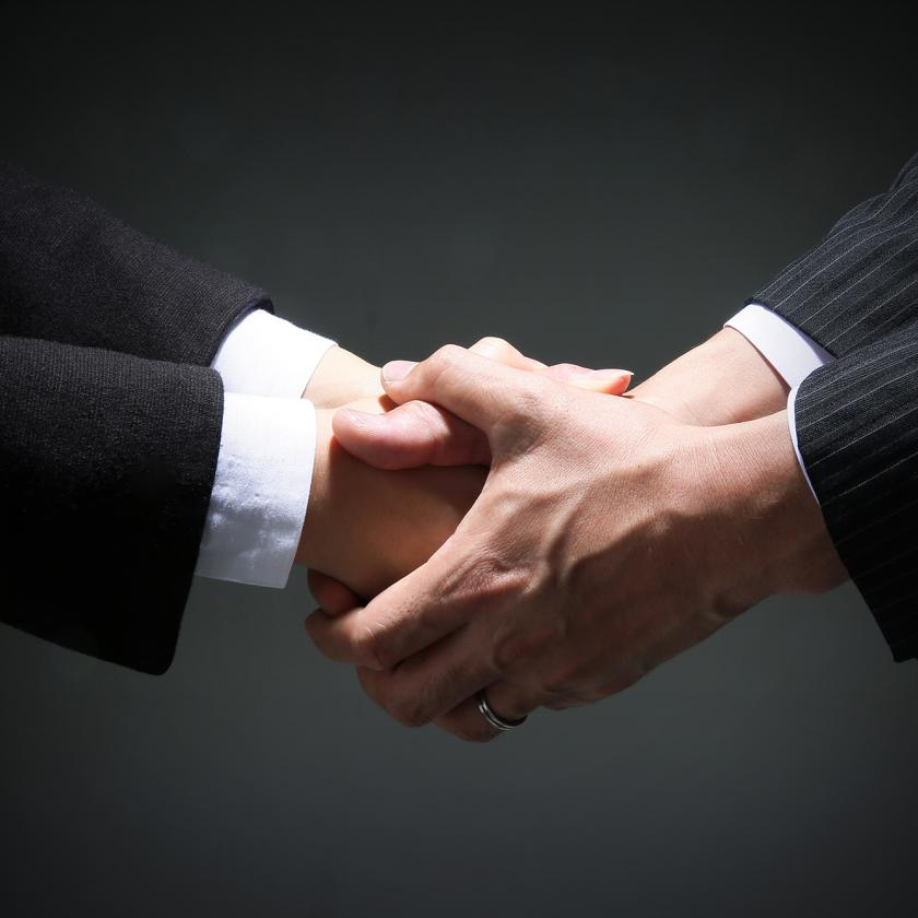 Two people in suits shaking hands