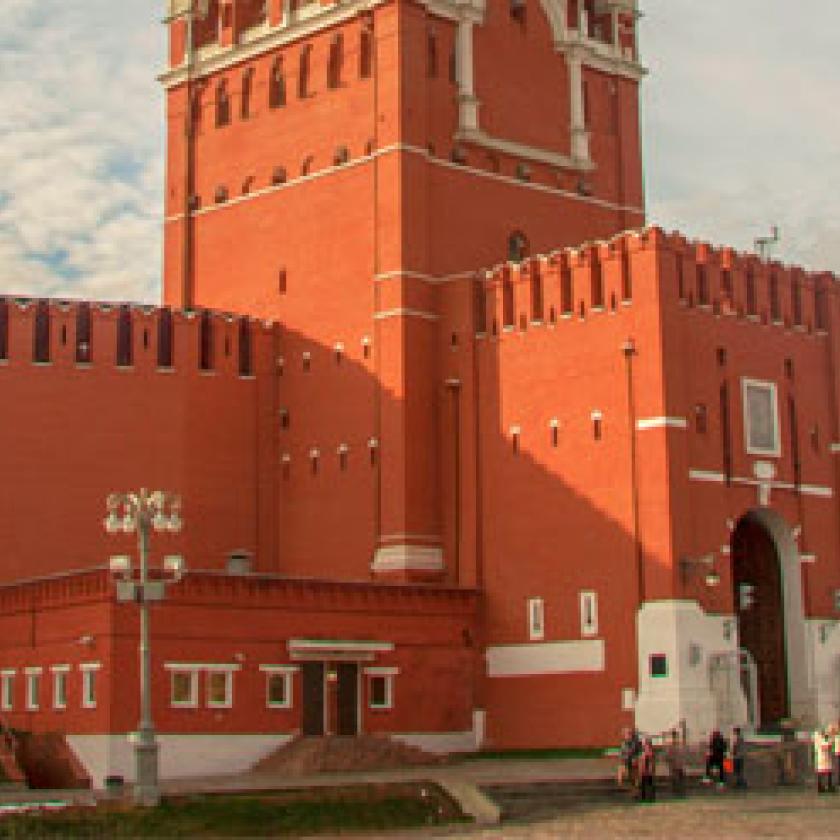 The red wall of a large building with a clock tower