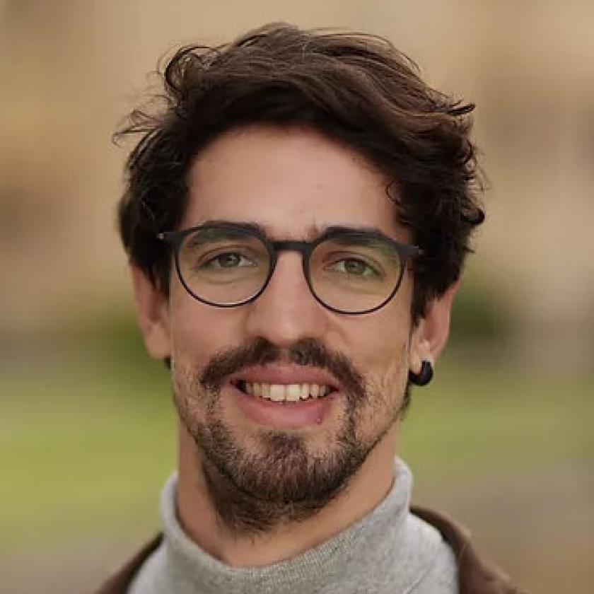 Image of a man wearing glasses smiling at the camera