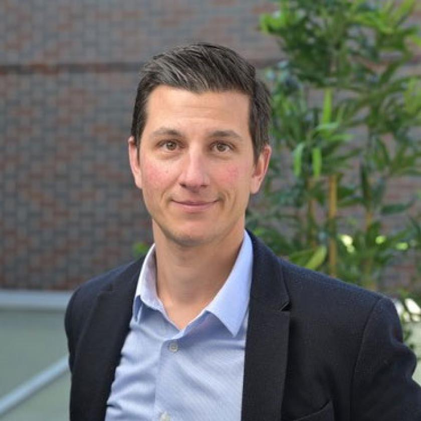 Image of a man wearing a suit smiling at camera