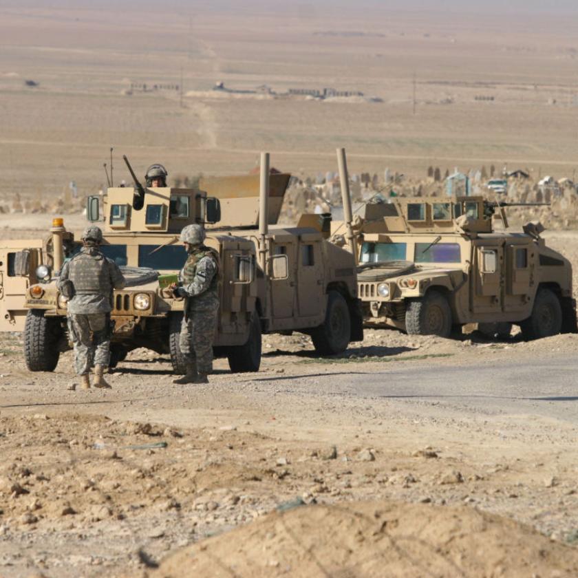 Army tanks on road in desert landscape