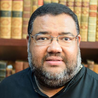Athol Williams profile photograph, with old library books in the background