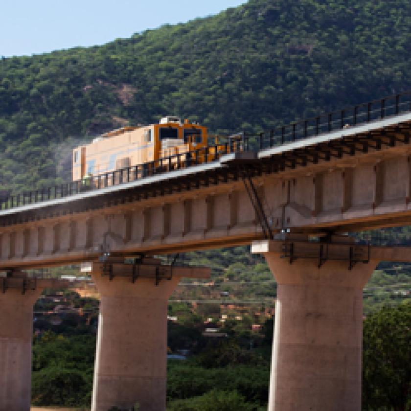  A picture containing outdoor, sky, train, bridge.