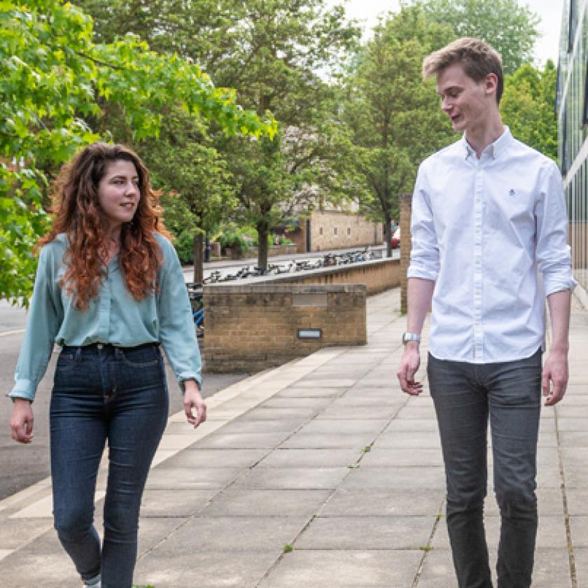 Three people walking together in a row, talking