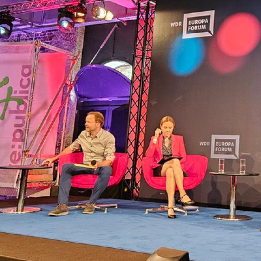 Image of a panel of people sat in chairs on a stage