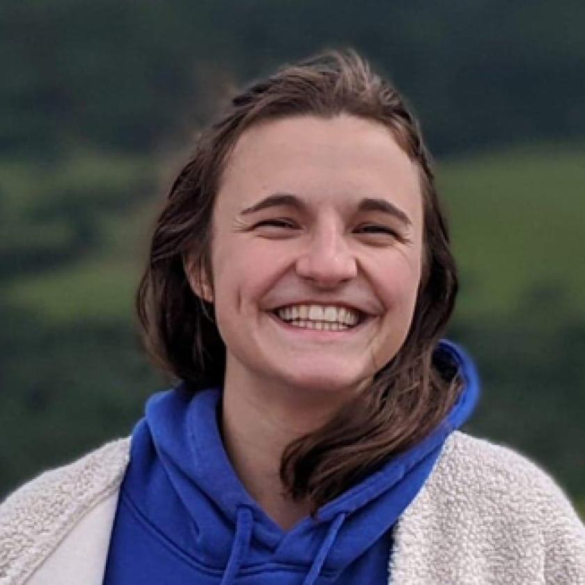 Image of a woman smiling at camera with a mountain in the background