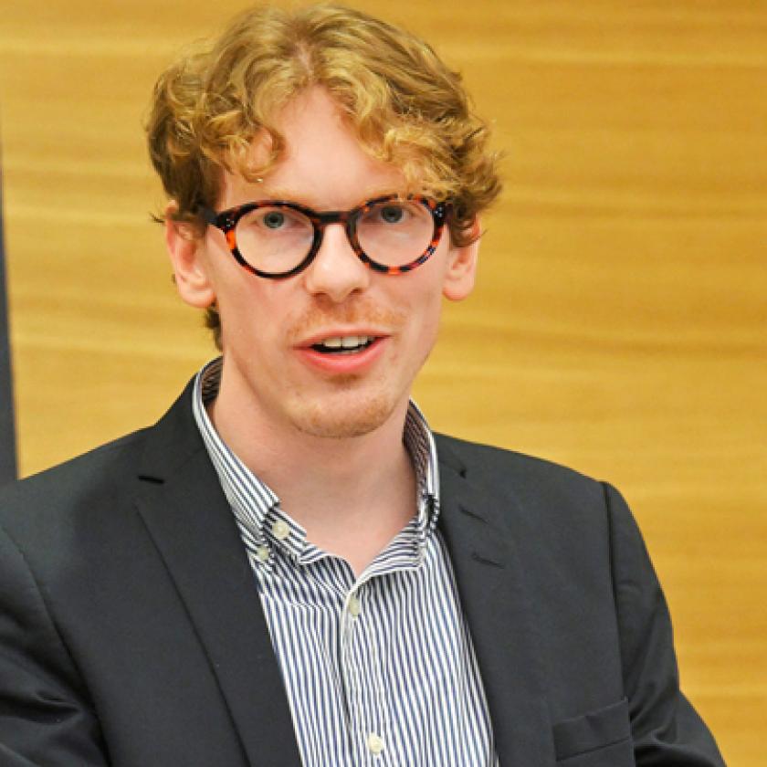A person standing at a podium with a computer.
