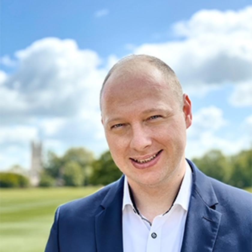 image of a person wearing a suit smiling at the camera