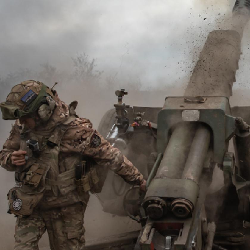 A group of soldiers in uniform standing next to a cannon.