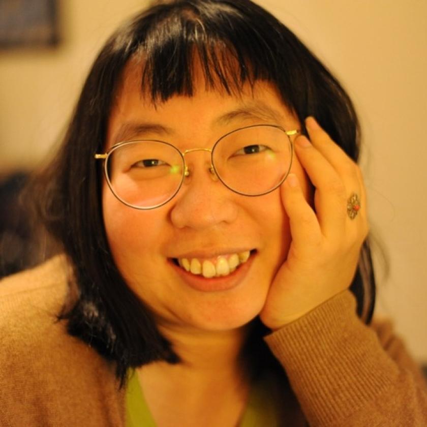 Image of a woman wearing glasses smiling at the camera
